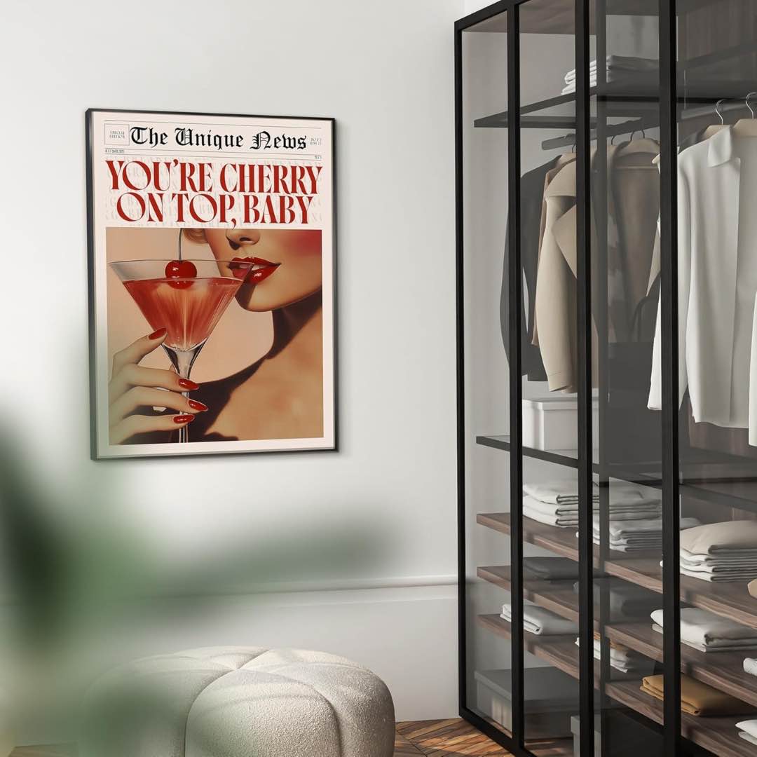 Dieses stilvolle Wandbild in den Maßen 50x70cm zeigt eine Frau mit einem Cocktailglas und einer leuchtend roten Kirsche und besticht durch seine einzigartige Farbgebung in Rot- und Beigetönen. Der elegante Rahmen verleiht dem Bild zusätzliche Raffinesse. Der Druck ist in Beige umrandet und über dem Bild steht "You're cherry on top, baby". Das Design erinnert an einen Zeitungsartikel.
