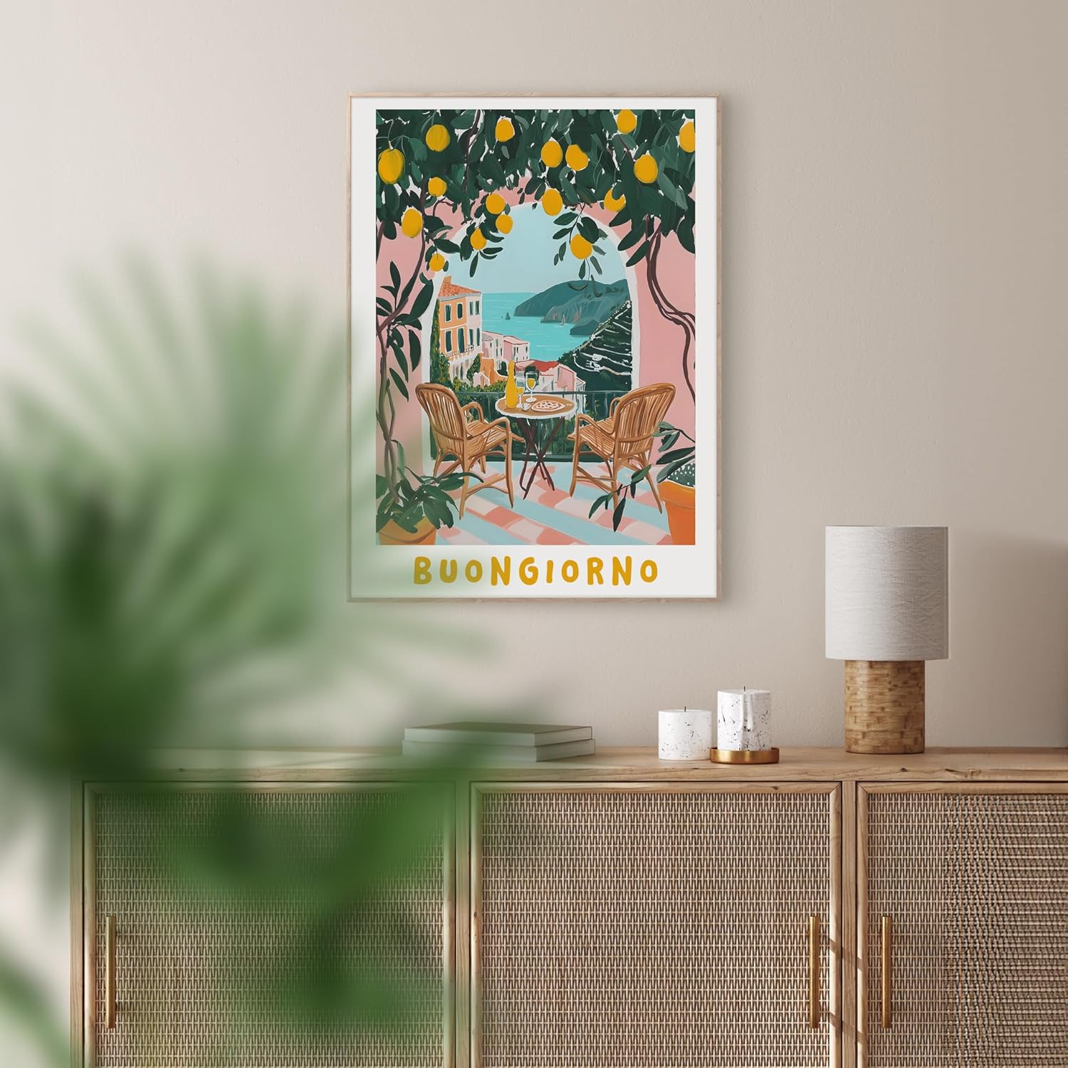 Das Rahmenbild in den Maßen 50x70cm zeigt im malerischen Stil und in kräftigen Farben einen Balkon in Italien mit Blick auf das Meer. Gelbe Zitronen mit grünen Blättern ragen über den Balkon. Der Balkon ist eingemauert mit einem schönen Rundbogen in rosa. Auf dem Balkon stehen zwei Rattanstühle mit einem kleinen runden Tisch.