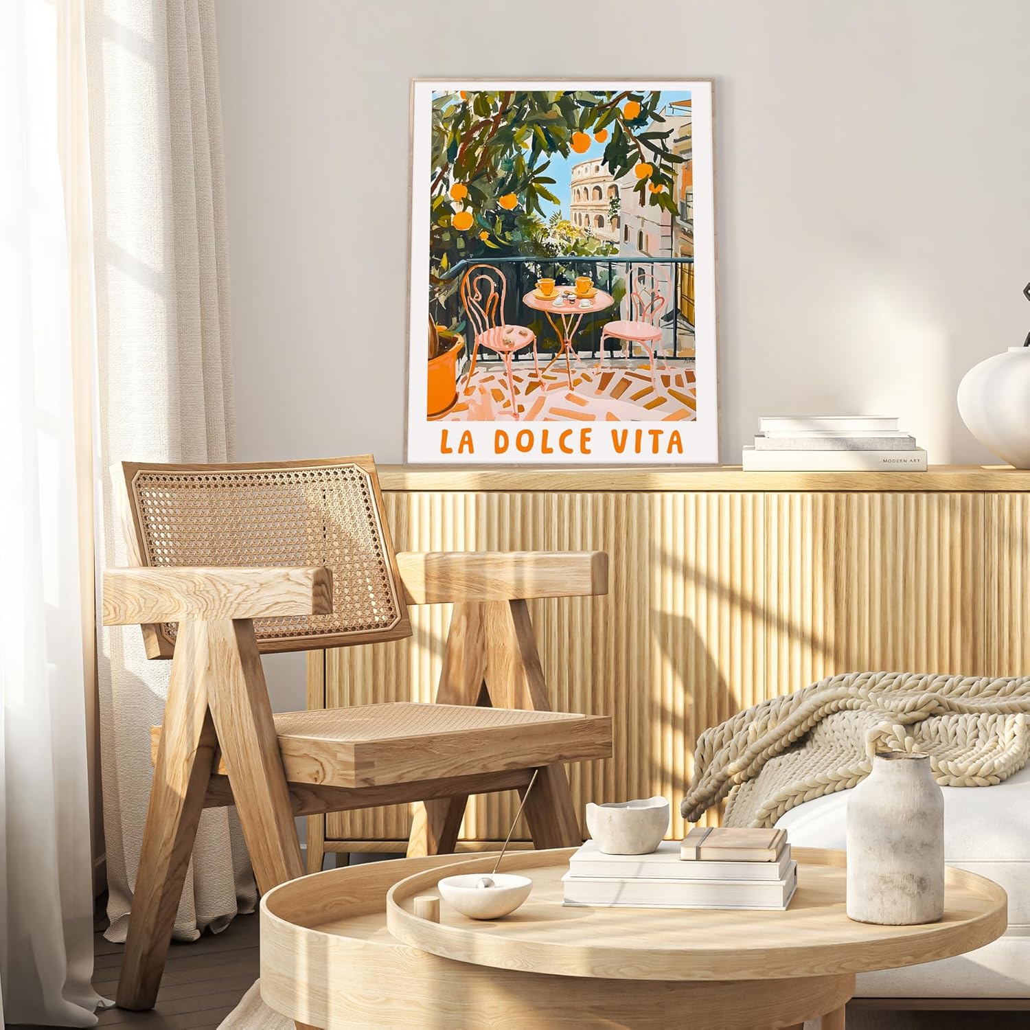 Das Rahmenbild in den Maßen 50x70cm zeigt im malerischen Stil und in kräftigen Farben einen Balkon in Italien mit Blick auf Rom. Orangen mit grünen Blättern ragen über den Balkon und der Himmel ist blau.  Der Balkon hat ein Geländer und es sind zwei Stühle mit einem kleinen runden Tisch in rosa zu sehen. Auf dem Tisch stehen zwei Tassen in der Farbe Orange. Der Blick fällt über die Stadt Rom und ein Teil des Kolosseum ist zu sehen.